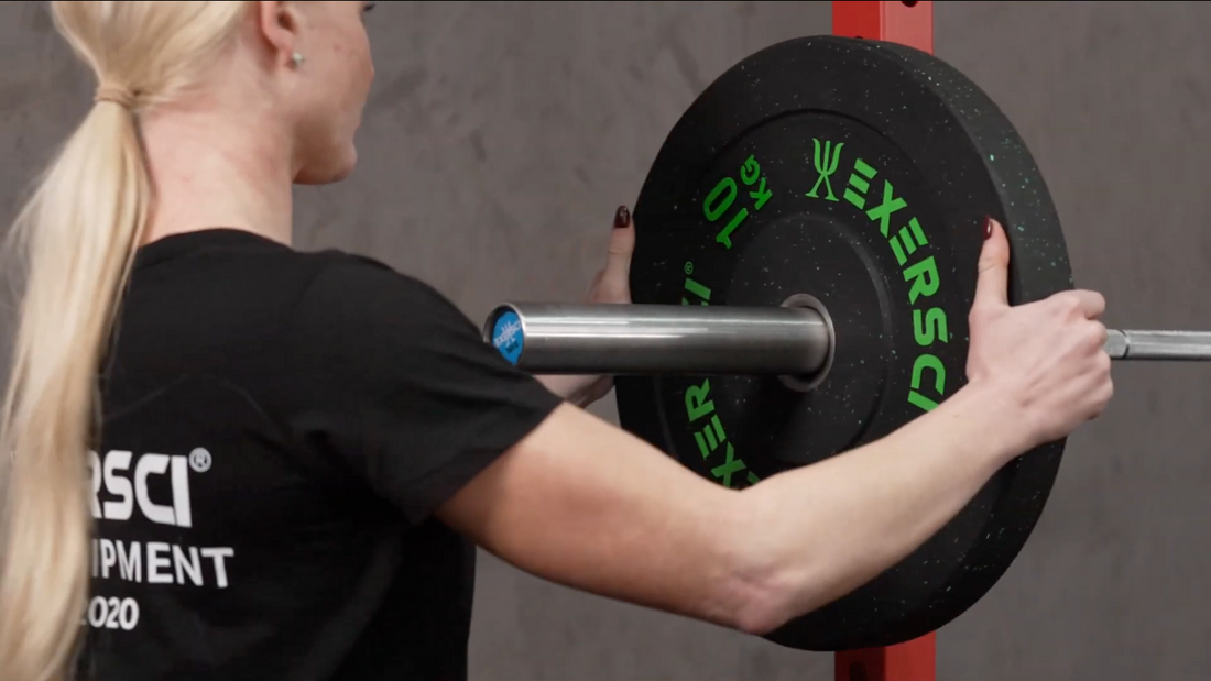 A woman setting up an  Exersci® Olympic Barbell with Rubber Olympic Bumper Plate to illustrate the Exersci blog post entitled 'Barbell Lifting for Beginners: Everything You Need to Know'