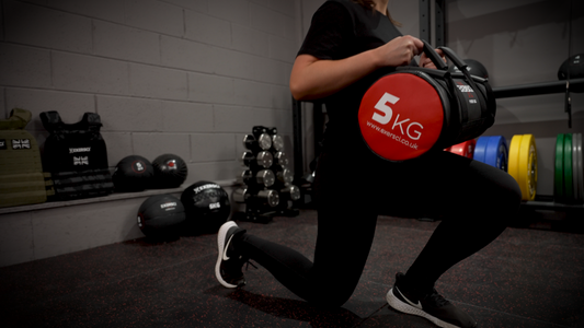 An image of a woman performing lunges with an Exersci power bag to illustrate the Exersci blog post entitled 'Why Should You Use Power Bags in Your Training?'