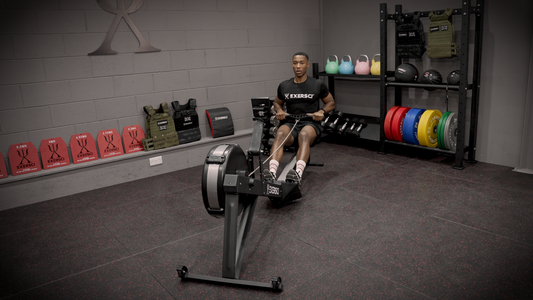 Image of a man on a rowing machine in an Exersci branded gym to illustrate the Exersci blog entitled 'Home Gym Vs Gym Membership: Which One Reigns Supreme?'
