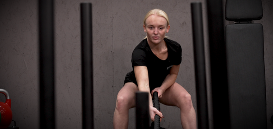 An image of a woman performing sled rope pulls with the Exersci weight sled to illustrate the Exersci blog post entitled 'Pulling exercise and strength: An underrated key to injury-resiliant training' 