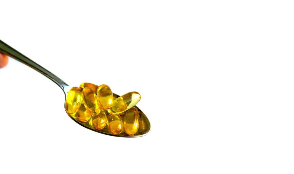Fish oil capsules on a spoon to illustrate the Exersci blog post entitled 'Using Fish Oil As A Gym Supplement & Fish Oil Benefits'