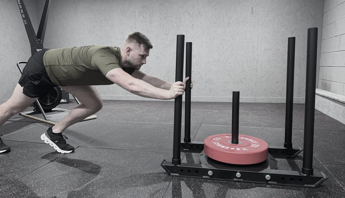 An image of a man performing sled pushes with the Exersci weight plate sled to illustrate the Exersci blog post entitled 'Over 40? Why strength training is more important than ever'